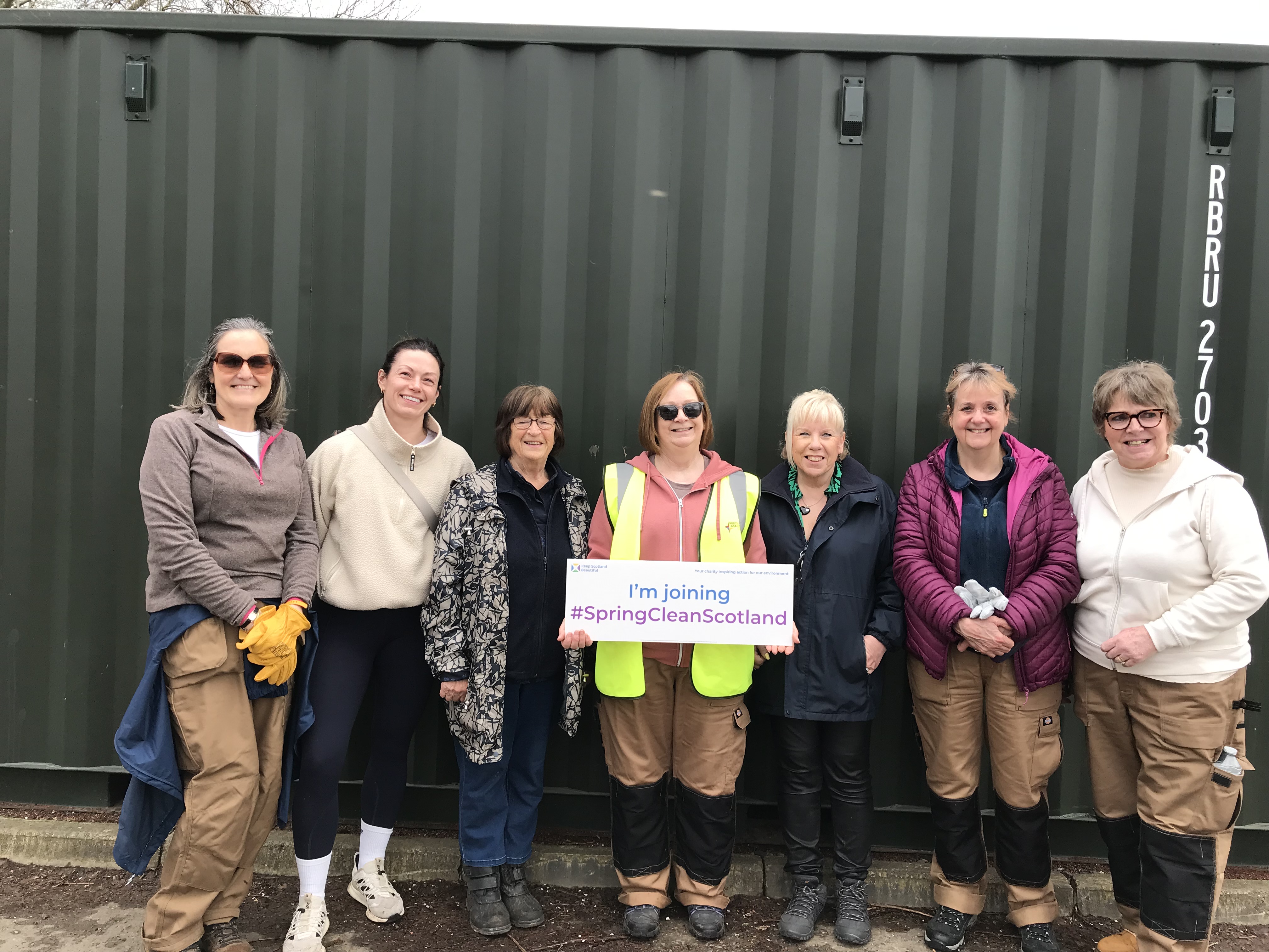 People posing with a Spring Clean Scotland sign
